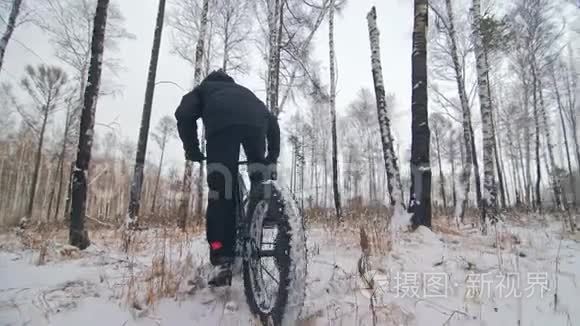 专业的极限运动员骑自行车在户外骑胖自行车。 后轮的近距离观察。 冬天骑自行车