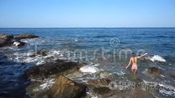 岩石海滩上美丽的年轻女士视频