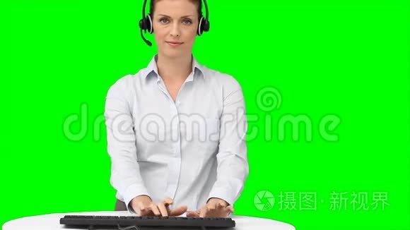 一个拿着耳机在键盘上打字的女人