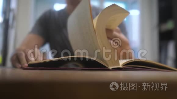 人在读一本书。 教育学习概念库。 男人打开书。 男人翻书页生活方式