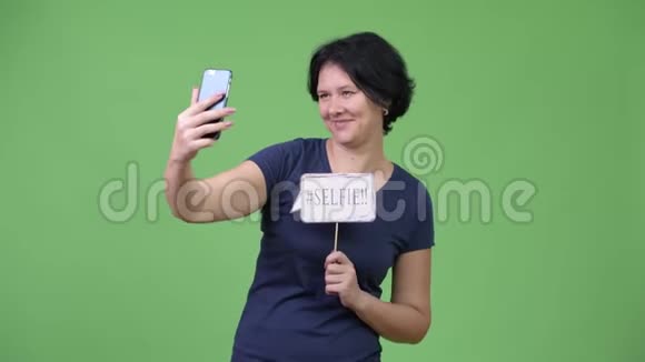 一位留着短头发的漂亮女人用电话视频的预览图