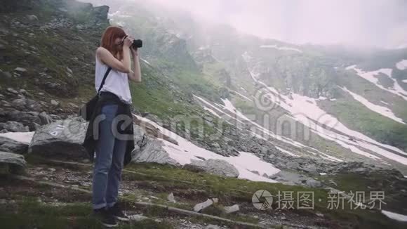 一个年轻的女徒步旅行者带着照片相机爬山。 罗马尼亚喀尔巴阡山脉