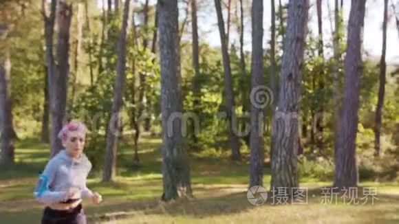 粉发在森林里慢跑的年轻女士视频