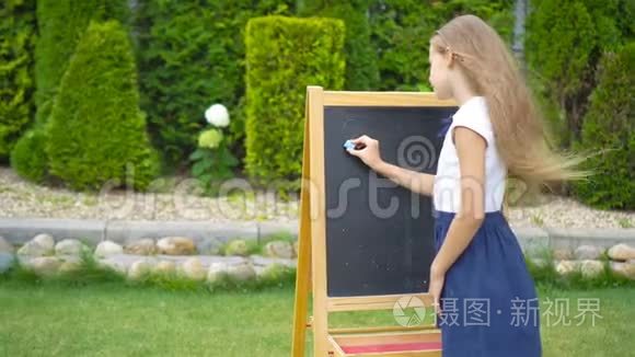 快乐的小女生带着黑板户外视频