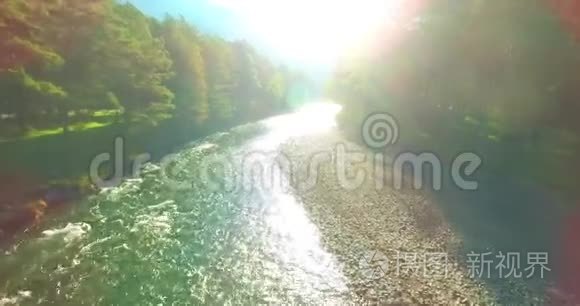 在阳光明媚的夏季早晨，低空飞行在带岩石的新鲜快山河上。