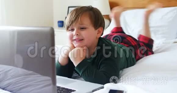 男孩在卧室里用笔记本电脑