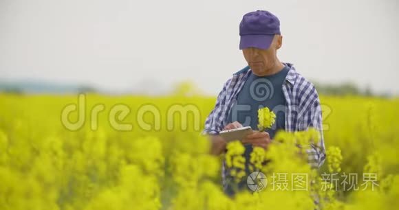 用数字平板电脑查看田间花开的农民