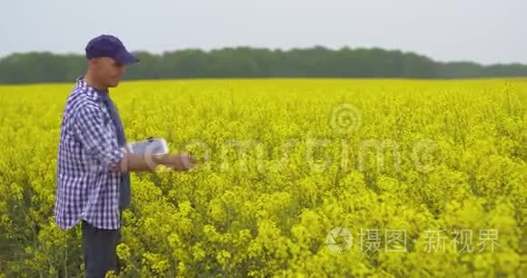 用数字平板电脑查看田间花开的农民