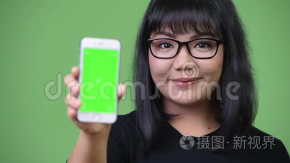 美丽的亚洲女商人展示手机视频