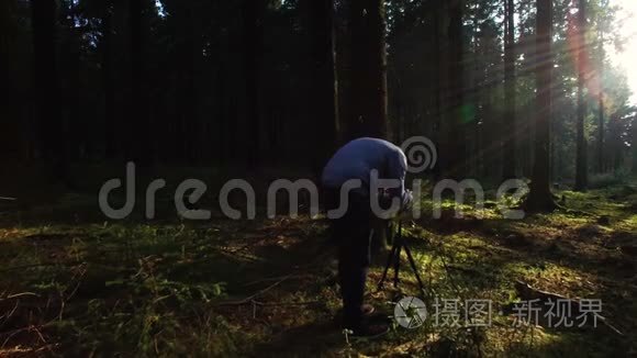 摄影师在春天的寂静森林里拍照