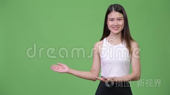 年轻漂亮的亚洲女商人展示了一些东西