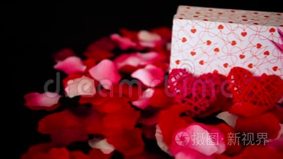 情人节礼物盒蜡烛燃烧和玫瑰花瓣装饰录像