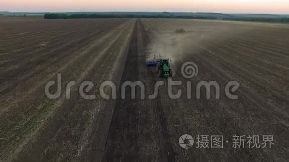 日落时拖拉机耕土的鸟瞰图视频