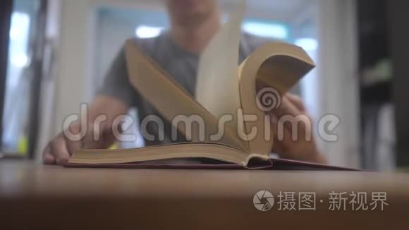 人在看一本书慢动作视频.. 生活方式教育学习理念。 男人打开书。 男人翻页