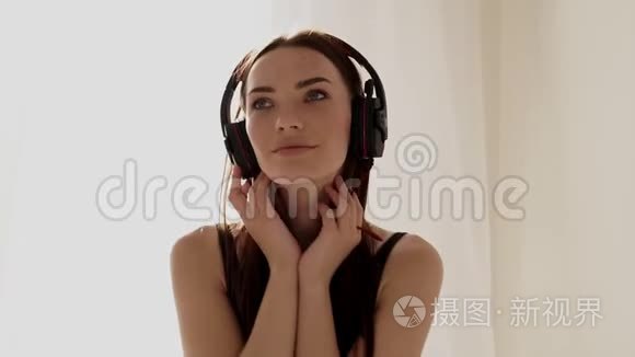 戴着大耳机在卧室听音乐的女孩