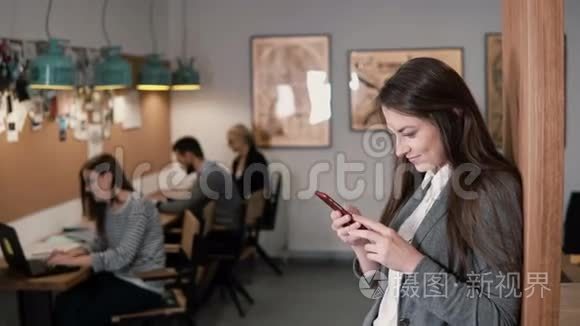 年轻漂亮的黑发女商人在现代的创业办公室里使用触摸屏平板电脑