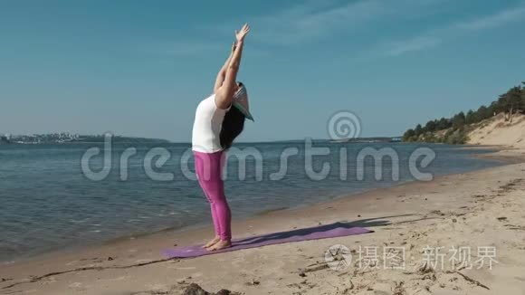 退休老妇人在海滩上做瑜伽
