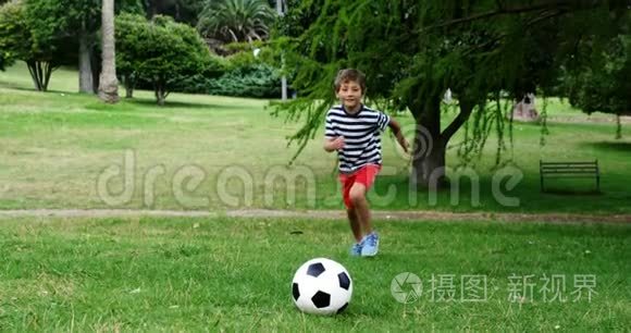 男孩在公园里踢足球视频