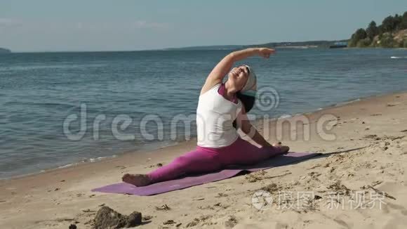 退休老妇人在海滩上做瑜伽视频