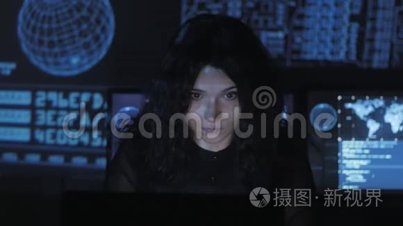 一幅年轻女性程序员在数据中心的一台电脑上工作的画像，里面装满了显示屏