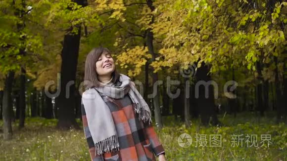 秋天的女孩在城市公园散步。 秋天的森林里快乐可爱美丽的年轻女子的肖像。