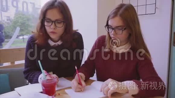 女大学生在咖啡馆学习，两个女朋友一起学习