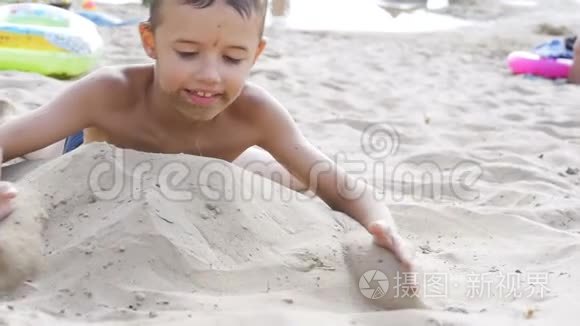 这孩子正在沙滩上慢动作地玩沙