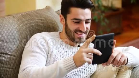 英俊的年轻人在家用电子书阅读视频