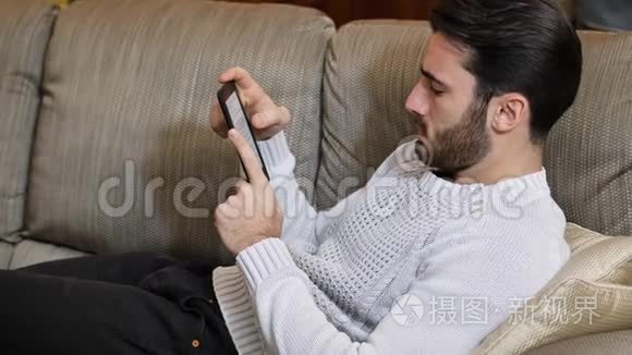 英俊的年轻人在家用电子书阅读视频