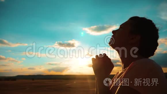 女孩在祈祷日落时分女孩双手合十形成祈祷的剪影慢动作视频女孩双手合