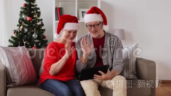 圣诞快乐的老夫妇带着平板电脑视频