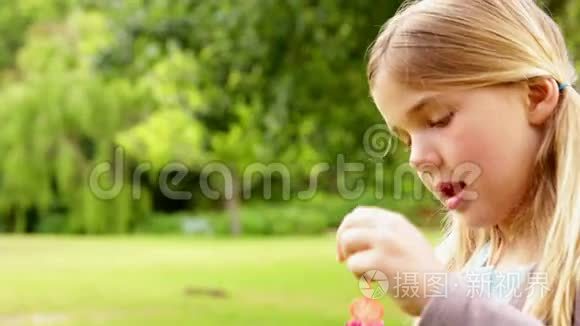 可爱的小女孩在公园里吹泡泡视频