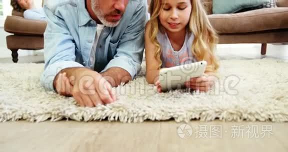 父亲和女儿在客厅里用数码平板电脑