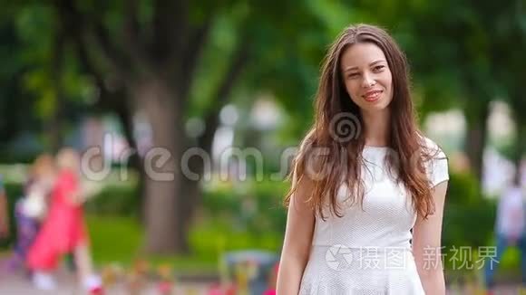 美丽的年轻女子肖像户外。 公园里幸福美丽的女人微笑的肖像