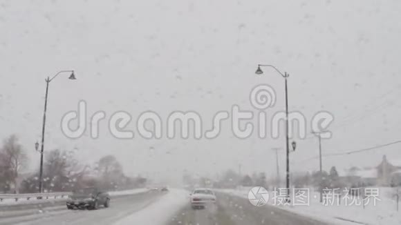 在寒冷的冬季暴风雪中驾驶汽车行驶在道路上