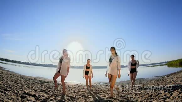 黎明时分，四个女孩在湖边沙滩上跳舞