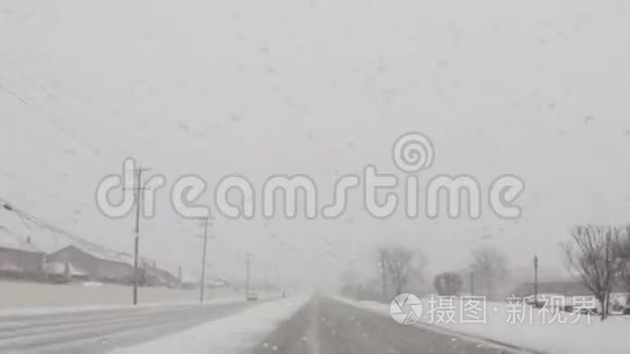在寒冷的冬季暴风雪中驾驶汽车行驶在道路上