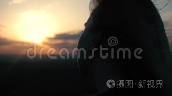 夕阳背景上美丽的女孩