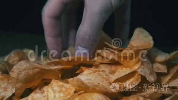 马铃薯芯片在黑色背景下旋转视频