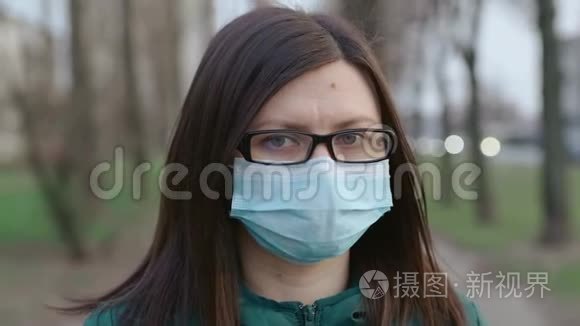 一个戴着眼镜和医用口罩的年轻女孩站在街上。