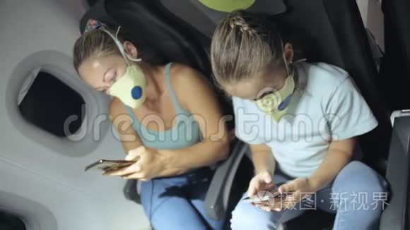 家庭妇女和儿童婴儿旅行旅游白种人在飞机上戴着防护医疗面罩。 使用