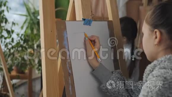 一个拿着铅笔的少女在艺术学校里坐在画架上画着静物。