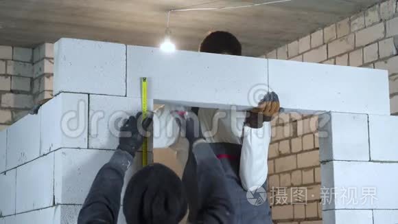 专业建筑工人在施工现场对加气混凝土砌块做标记