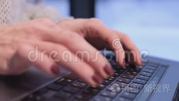 晚上，当蓝色的时刻已经来到窗外时，特写的女性双手在笔记本电脑键盘上打字