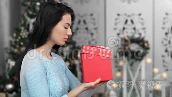 震惊的亚洲年轻女子打开圣诞礼盒，有满足的情绪。 中型摄影机