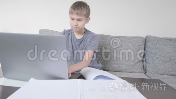男孩用笔记本电脑学习，在家做作业。 技术、远程教育、在家在线学习