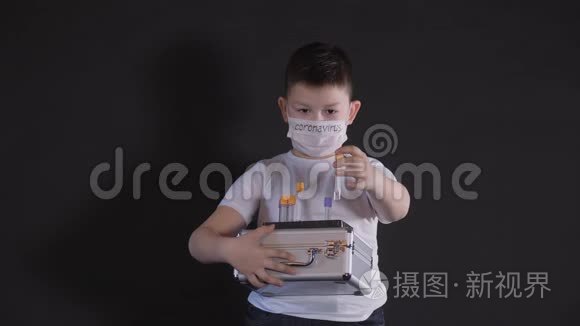 男孩拿着一个金属手提箱。 儿童检查带有病毒样本的医学试管。 男孩很小心