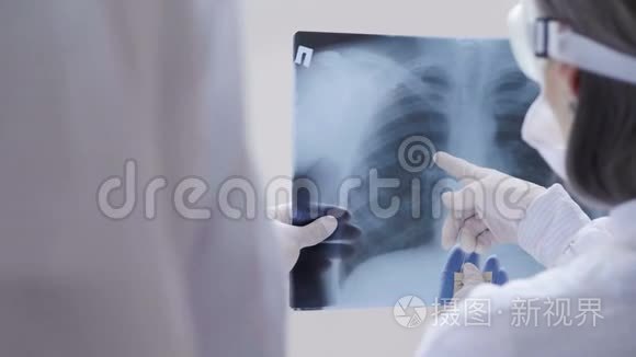 医生站在白色背景下检查X光检查一名Covid-19病人在诊所的肺炎。 冠状病毒
