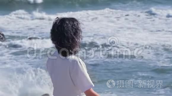 年轻女子在海边的岩石上沉思