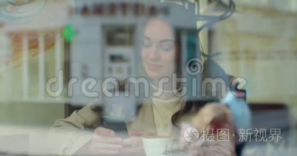 使用智能手机在咖啡馆喝咖啡的年轻女性在社交媒体上发短信，享受移动技术